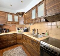A kitchen in a 4-room apartment with a wood-patterned floor and appliances.