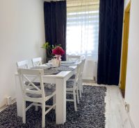 Dining room with a gray carpet and white furniture in a 4-room apartment.