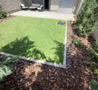 Garden of a 2-room apartment in Galanta with a grassy area and terrace seating.