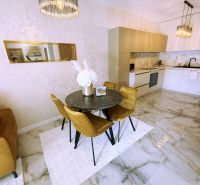 Dining area in a 2-room apartment with marble flooring and elegant lighting.