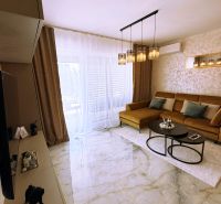 Living room in a two-room apartment with glossy tiles and a sofa.