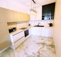 A kitchen in a 2-room apartment with marble flooring and minimalist furniture.