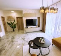 Living room in a two-room apartment with marble flooring and stylish lighting.