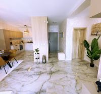 Interior of a 2-room apartment with a marble floor, bright kitchen, and dining area.