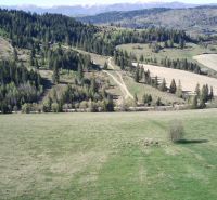 Agricultural and forest land in Čierny Balog with hills, forests, and a road in the countryside.