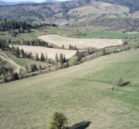A hilly landscape in Čierny Balog with agricultural and forest lands full of trees and meadows.