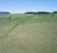 The landscape of Čierny Balog with extensive grass cover on agricultural and forest lands.