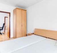 A double room with wooden decor and a wardrobe in a two-room apartment.