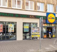 Lidl on Grösslingova Street in Bratislava - Old Town with passersby and a bicycle.
