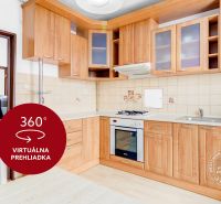 A kitchen with a gas stove and a dishwasher, a floor with a wooden decor in a 2-room apartment.