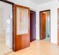 Hallway of a 2-room apartment with a wooden decor floor, entrance to the kitchen and bathroom.