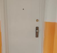 White doors in the hallway of a 4-room apartment with orange walls.