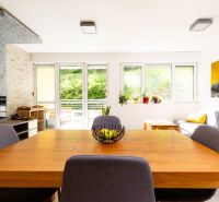 Living room in a two-room apartment with a wooden table and a sofa, view of the terrace.