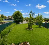 A garden at a family house in Šalgovce with a well-maintained lawn and flower beds.