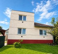 A family house in Šalgovce with a well-maintained lawn under a blue sky.