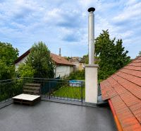 The rooftop terrace of a family house in Šalgovce with a chimney and a view of the garden.
