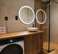 Bathroom in a 2-room apartment with a sink, shower, and floor with a wooden decor.