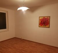 A room in a 3-room apartment with a wooden decor floor and a rose painting.