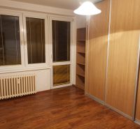 A room with a wooden floor decor and a large built-in wardrobe in a 3-room apartment.