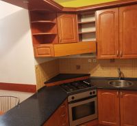 A kitchen in a 3-room apartment with wooden cabinets and ceramic tiles.