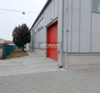 The exterior of offices in KE - Džungľa with red doors and a paved walkway.
