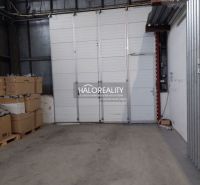 In warehouses and halls, there are pallets with boxes and large white doors.