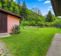 A family house in Dolná Mariková surrounded by a garden with a lawn and storage space.