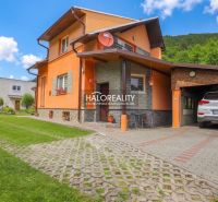 A family house in Dolná Mariková with a garage, lawn, and parking area in front of the house.