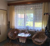 A room in a family house with a table, chairs, and a large window with a view.