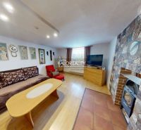 Living room in a family house with a stone fireplace and a floor with a wooden decor.