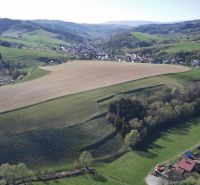 The landscape in Čierny Balog with agricultural and forest lands on the slopes of the hills.