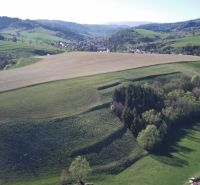 Agricultural and forest lands around Čierny Balog with a view of picturesque mountains.