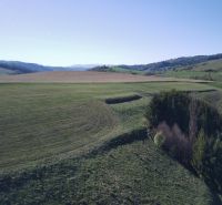 The landscape around Čierny Balog with agricultural and forest lands, on a clear day.