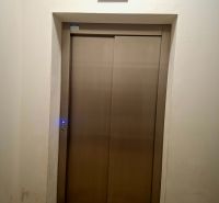Metal elevator doors with a display in a studio apartment.