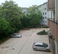 Parking lot on Športová Street in Dunajská Lužná with cars and greenery in the background.