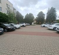 Parking lot with cars on Športová Street in Dunajská Lužná in front of the building.