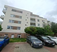 Apartment building on Športová Street in Dunajská Lužná with a parking lot and cars in front of the building.