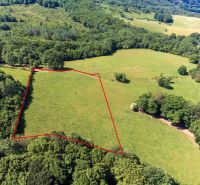 Recreational plots in Ostrá Lúka surrounded by greenery and trees.