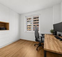 A study in a 3-room apartment with a wood-patterned floor, white cabinets, and a desk.