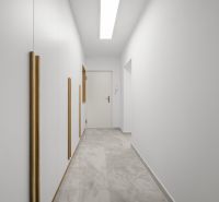 A bright hallway with white walls and tiles in a 3-room apartment.