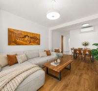 Living room in a 3-room apartment, sofa, table, and floor with wooden decor.