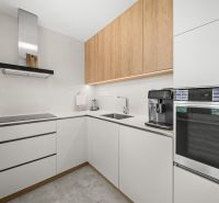 A kitchen in a 3-room apartment with white cabinets and built-in appliances.
