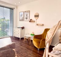 Children's room in a family house with a wooden decor floor and a large window.