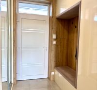 Entrance hall in a family house with a tiled floor and storage space with a wooden decor.