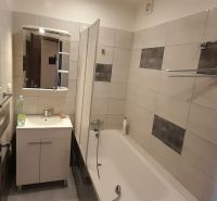Bathroom in a 2-room apartment with a bathtub and a washbasin cabinet.