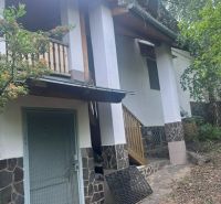 A cottage in Jablonov nad Turňou, surrounded by greenery, with a terrace and stone cladding.