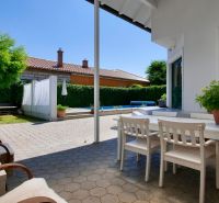The terrace of a family house in Žabokreky with white furniture and greenery.