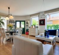 Living room in a family house with a wooden decor floor, seating area, and table.