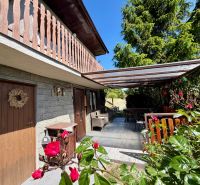 A cottage in Kunov near Senica with a wooden balcony and a romantic terrace full of flowers.