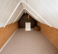 The attic of the cottage with wooden decor and a rattan storage basket.